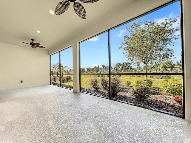 unfurnished sunroom with ceiling fan