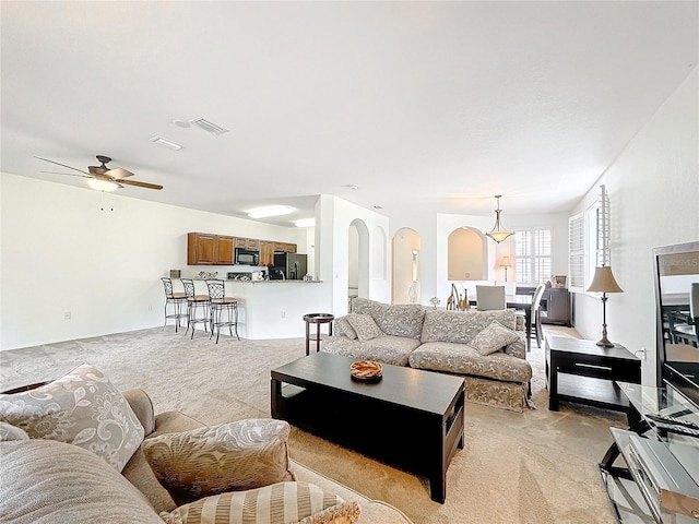 carpeted living room with ceiling fan