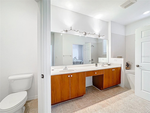 bathroom with a washtub, tile patterned floors, vanity, and toilet