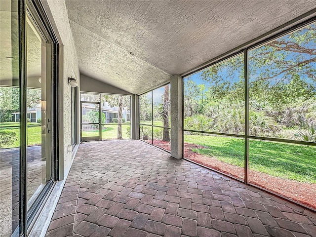 unfurnished sunroom featuring vaulted ceiling