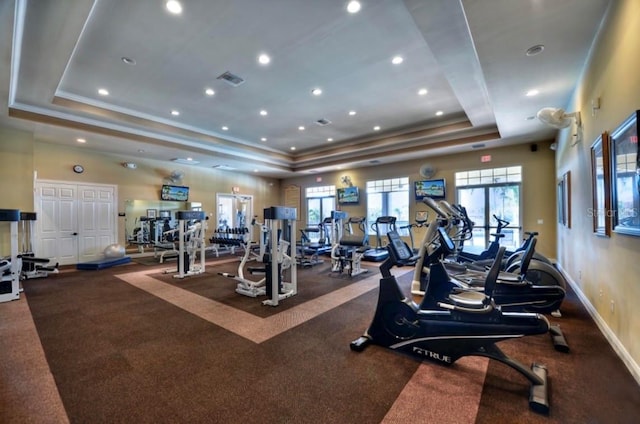 exercise room featuring a tray ceiling and crown molding