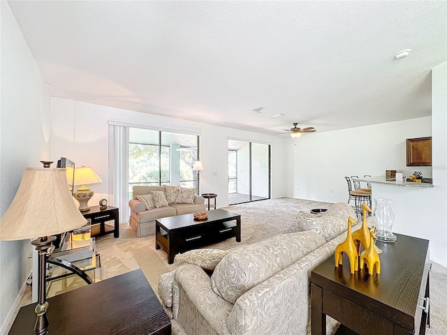 living room with light colored carpet and ceiling fan