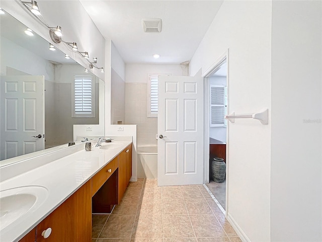 bathroom featuring a bathing tub, tile patterned flooring, and vanity