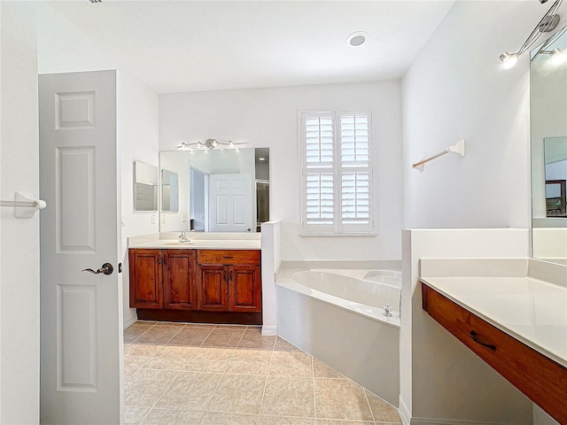 bathroom featuring a bathing tub, tile patterned flooring, and vanity