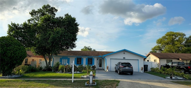 ranch-style house with a garage and a front lawn