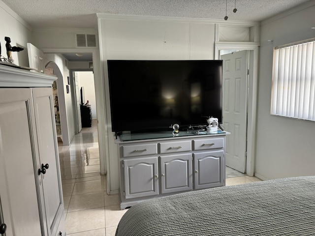 tiled bedroom featuring crown molding and a textured ceiling