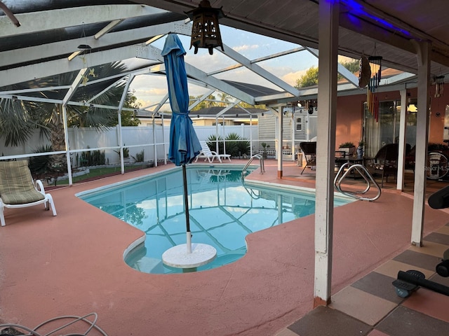 view of swimming pool featuring a lanai and a patio area