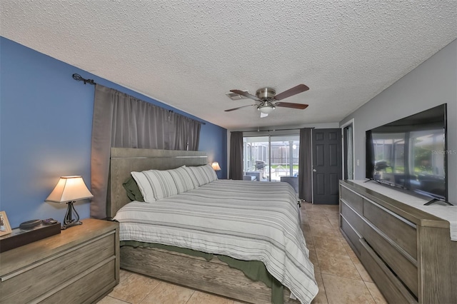 bedroom featuring ceiling fan, light tile patterned floors, and a textured ceiling