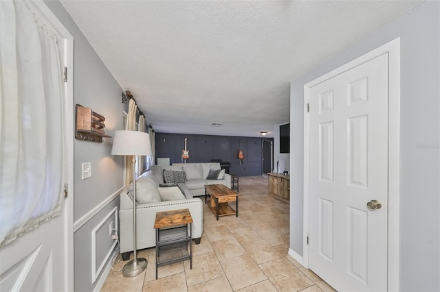 living room featuring a textured ceiling and light tile patterned floors