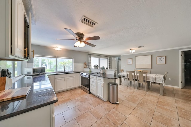 kitchen with white cabinetry, light tile patterned flooring, sink, appliances with stainless steel finishes, and kitchen peninsula