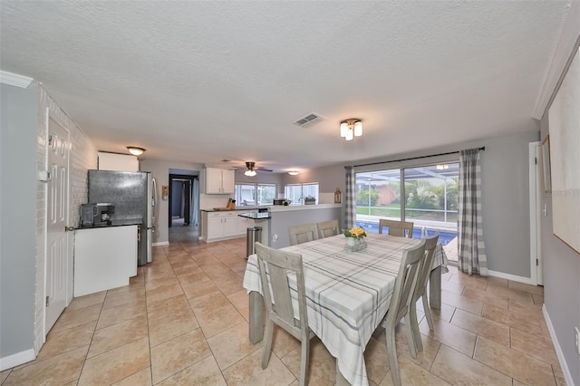 tiled dining room featuring a textured ceiling and ceiling fan