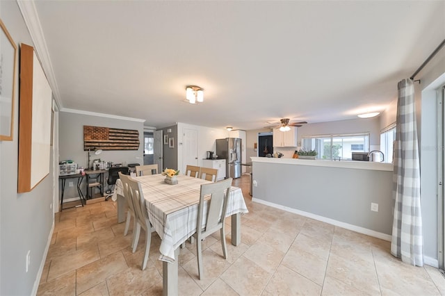 tiled dining room featuring crown molding and ceiling fan