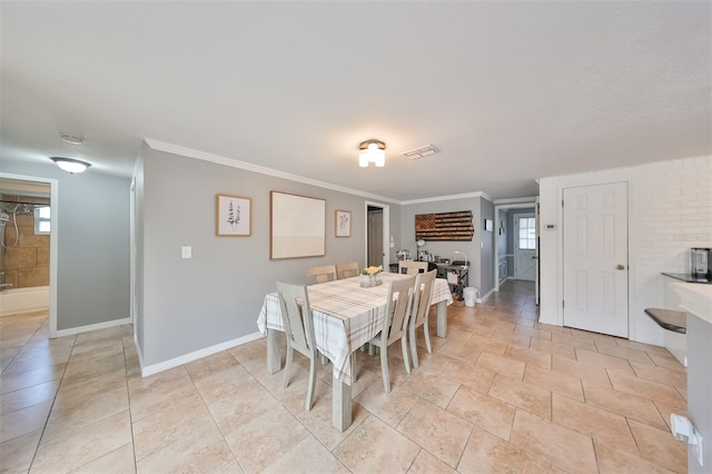 dining room featuring light tile patterned floors and crown molding