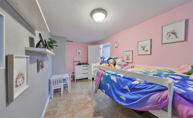 bedroom featuring light tile patterned flooring and a textured ceiling