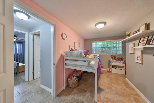 bedroom with a textured ceiling and light tile patterned floors