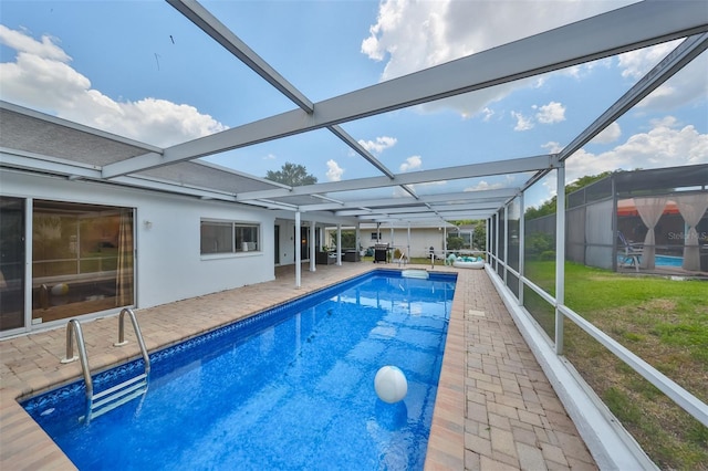 view of pool with a patio, glass enclosure, and a lawn