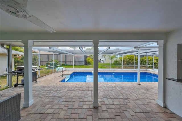 view of swimming pool with a patio area, grilling area, and glass enclosure