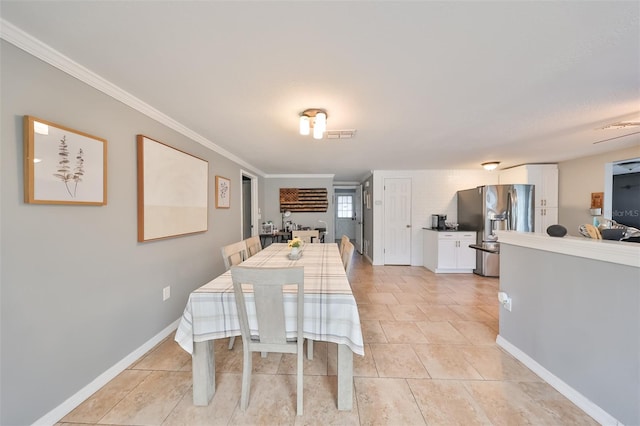 tiled dining space featuring crown molding