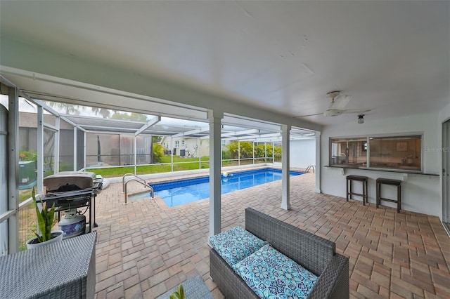 view of swimming pool with an outdoor living space, a patio area, a lanai, and ceiling fan