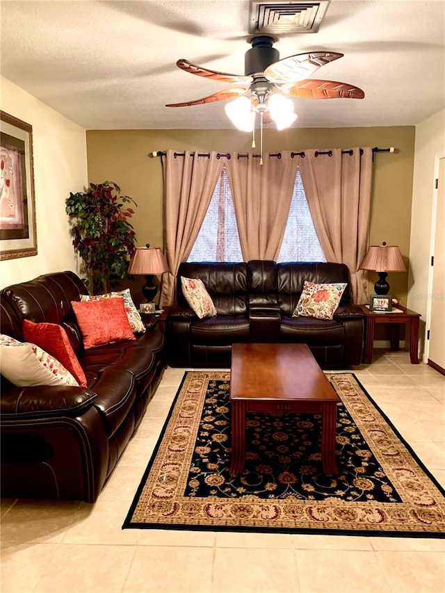 tiled living room featuring a textured ceiling and ceiling fan