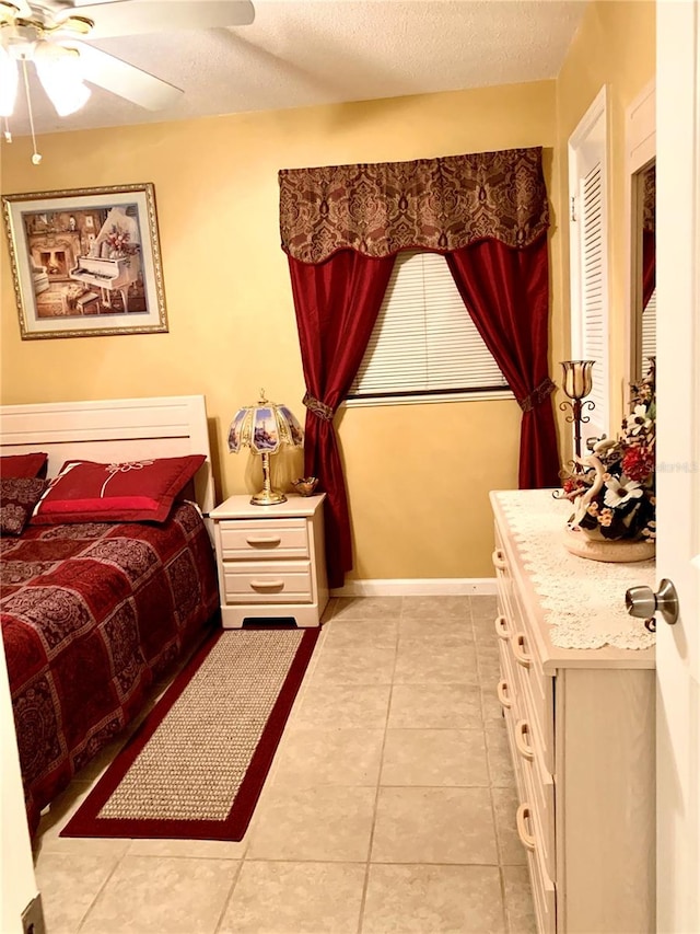 bedroom with ceiling fan, a textured ceiling, and light tile flooring