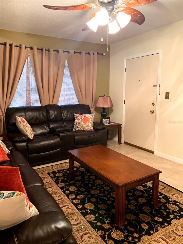 living room featuring ceiling fan, a textured ceiling, and light tile flooring