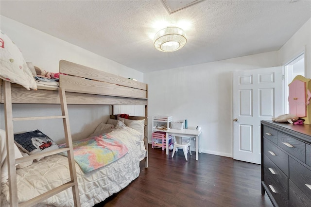 bedroom with dark hardwood / wood-style floors and a textured ceiling