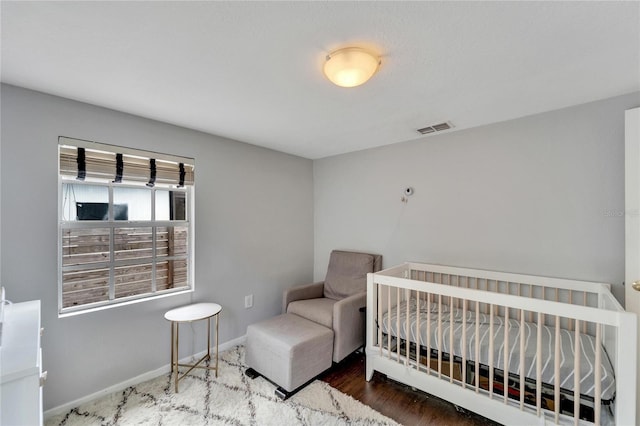 bedroom featuring a crib and hardwood / wood-style floors