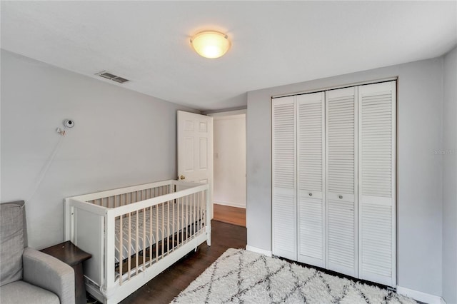 bedroom with dark hardwood / wood-style flooring and a closet