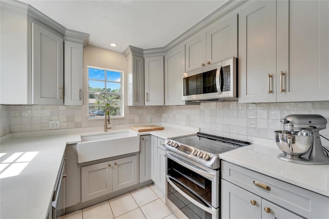 kitchen featuring sink, tasteful backsplash, light tile floors, and stainless steel appliances