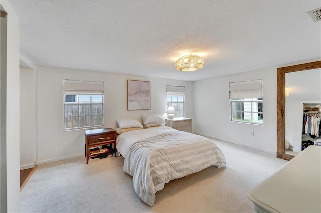 bedroom featuring light carpet and multiple windows