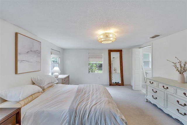 carpeted bedroom featuring a textured ceiling and multiple windows