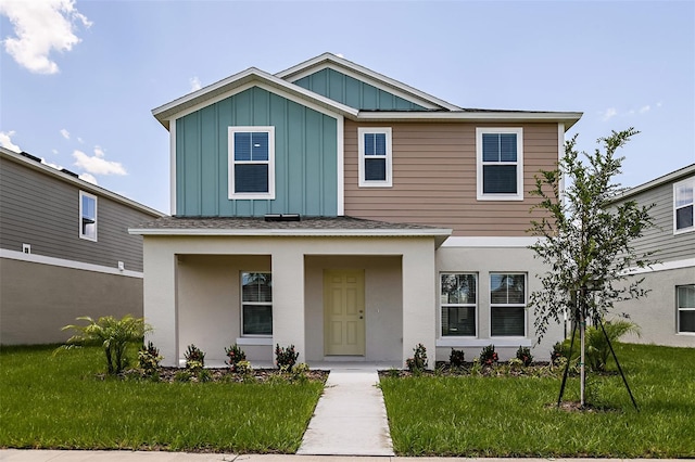 view of front of property with board and batten siding, a shingled roof, and a front lawn