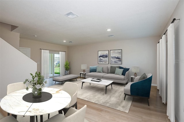 living area featuring a textured ceiling, light wood finished floors, visible vents, and recessed lighting