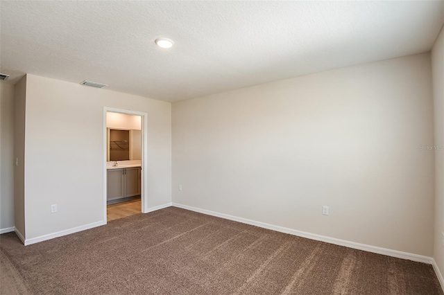 unfurnished room with a textured ceiling and carpet