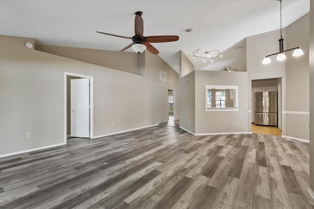 empty room featuring high vaulted ceiling, ceiling fan, and hardwood / wood-style flooring