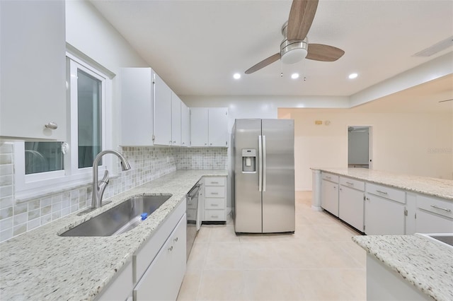 kitchen featuring stainless steel appliances, white cabinetry, tasteful backsplash, sink, and ceiling fan