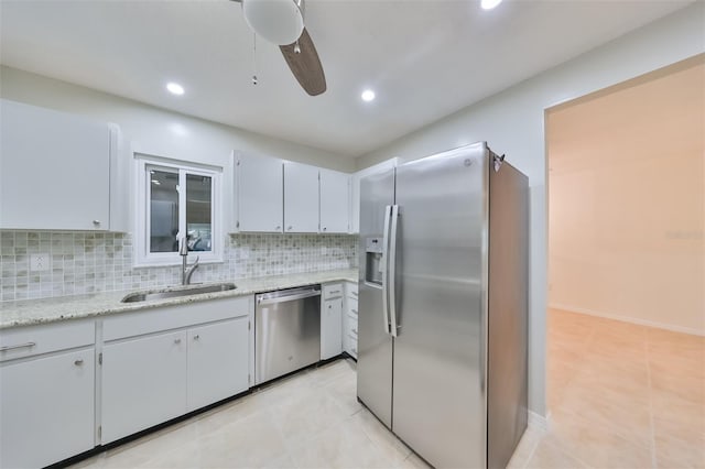 kitchen featuring light tile patterned floors, stainless steel appliances, backsplash, and a sink