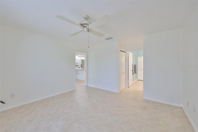 empty room with ceiling fan, visible vents, and baseboards