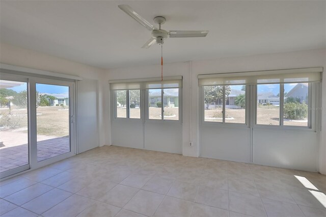 tiled empty room featuring ceiling fan