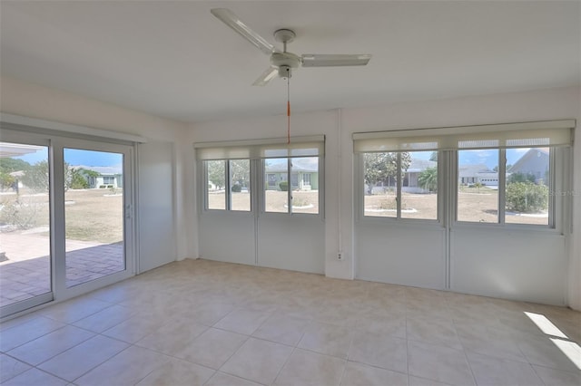 unfurnished sunroom featuring a ceiling fan