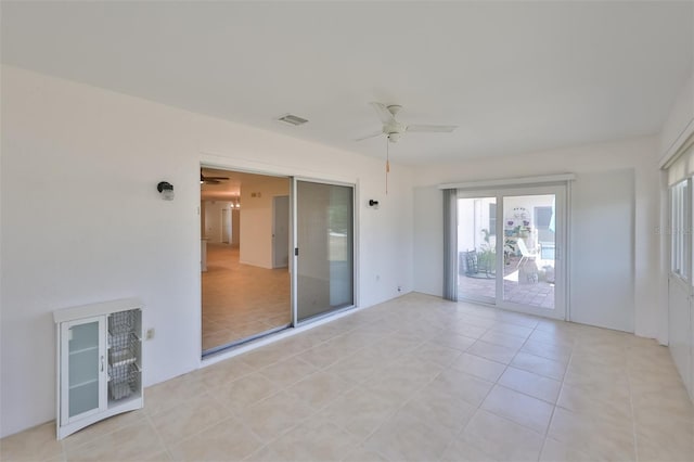 empty room with a ceiling fan, visible vents, and light tile patterned floors