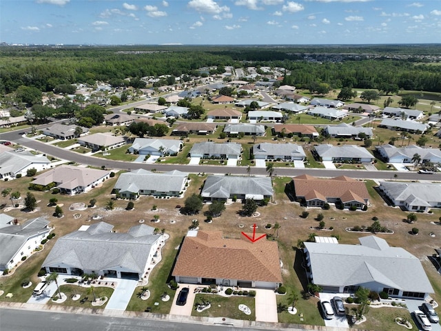 drone / aerial view featuring a residential view and a view of trees