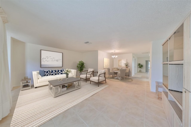 living room with light tile patterned flooring, a notable chandelier, and a textured ceiling