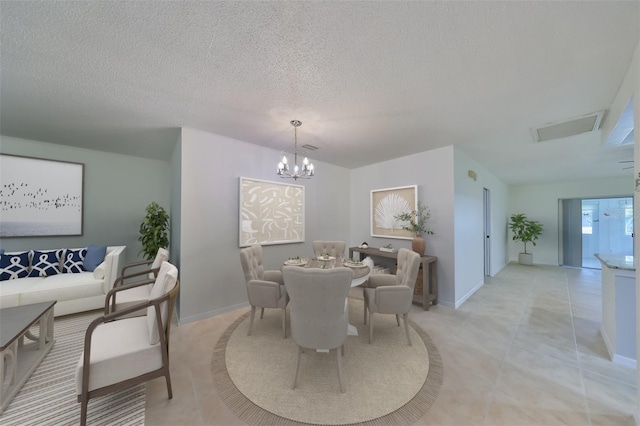 dining space with a textured ceiling, an inviting chandelier, and light tile patterned flooring