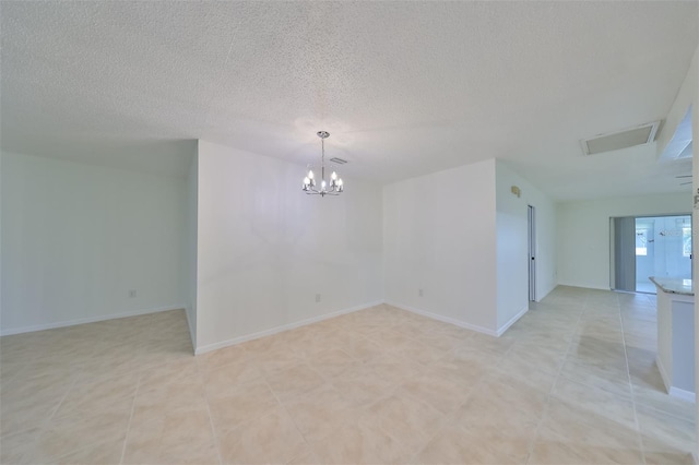 unfurnished room with light tile patterned floors, an inviting chandelier, and a textured ceiling