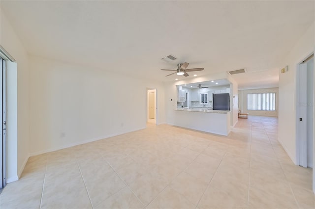 unfurnished living room featuring ceiling fan and light tile patterned flooring