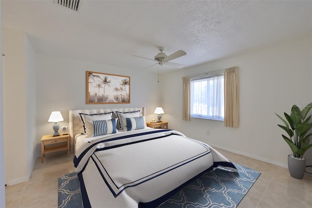 tiled bedroom featuring a textured ceiling and ceiling fan