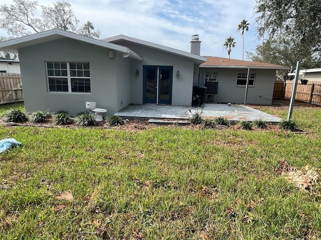 back of property featuring a patio and a yard