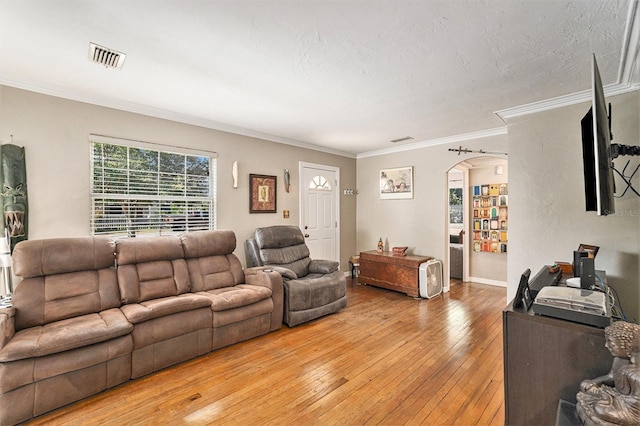 living room with crown molding, light wood-type flooring, and a textured ceiling